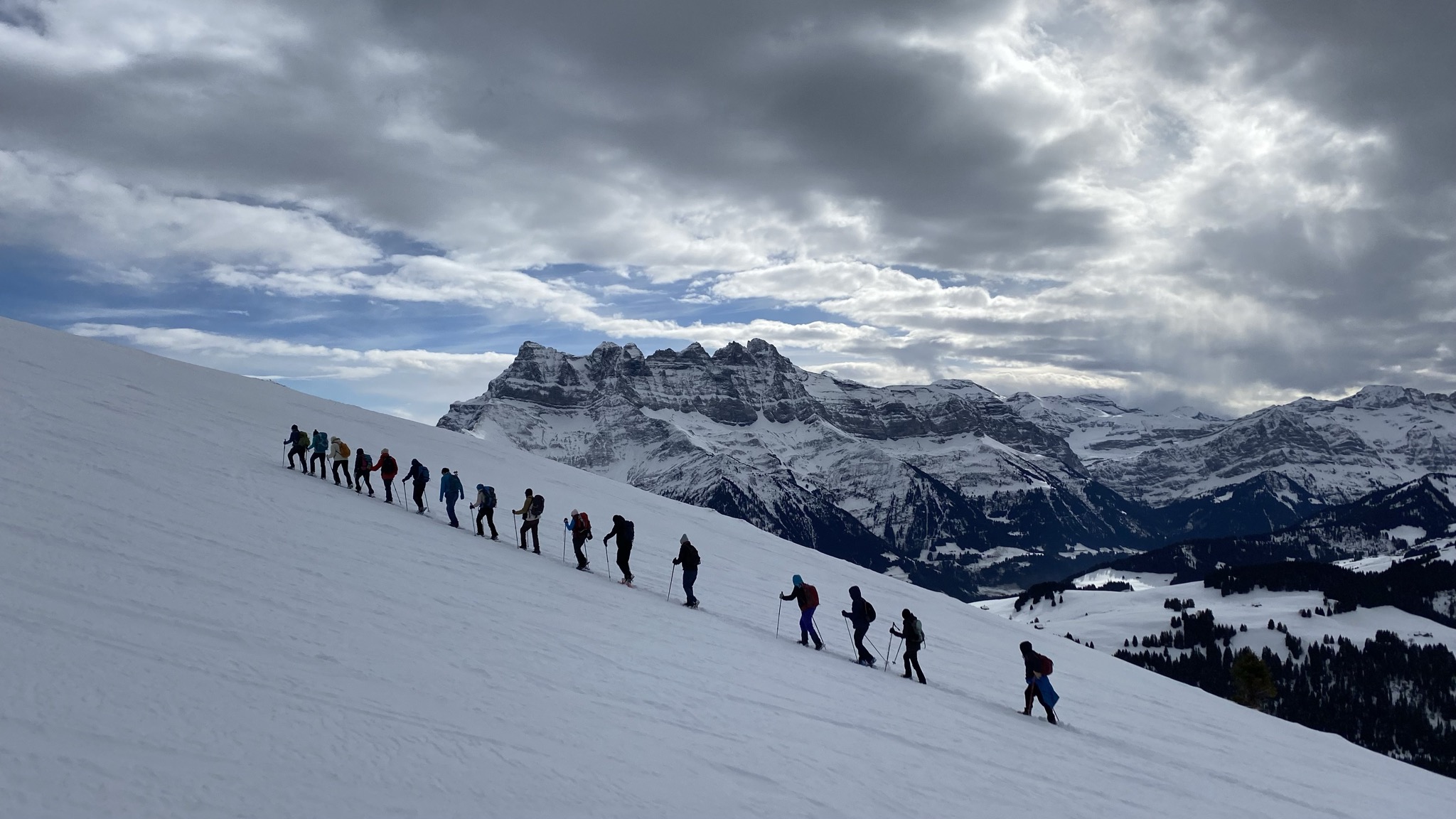 Groupe de retraitants en raquettes face aux Dents-du-Midi enneigées